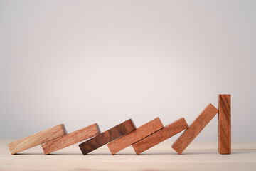 Many wooden block dominoes falling to one wooden block standing , resistance and stop risk...