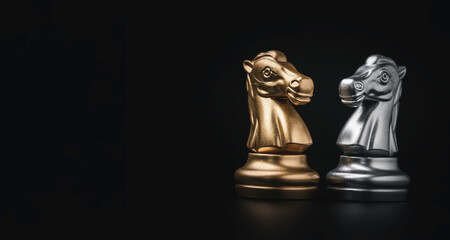 Face to face of golden and silver knight horse chess on black background with copy space , Business strategy and competition concept.