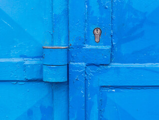 Partly rusted locked industrial door with scratched metal latch