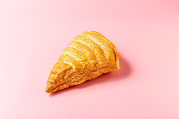 Fresh croissant on a pink background.