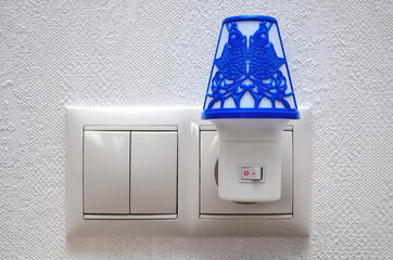 A small lamp in the socket. Blue night light