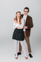 full length view of happy couple in vintage outfit posing on grey background