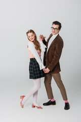 full length view of old fashioned couple dancing on grey