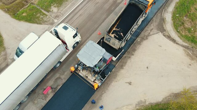 Aerial view Road service lays asphalt on the road. Workers measure the width of the road. Asphalting of the road