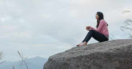 Woman sit on the mountain and enjoy the scenery view