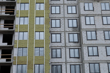 construction of a multi-storey residential building house part of the wall is covered with insulation