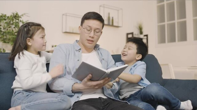 Tired father reading story to naughty kids, child behavior problems, parenthood
