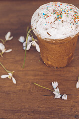 Easter cake on a wooden table, decorated with flowers of snowdrops. Easter background.