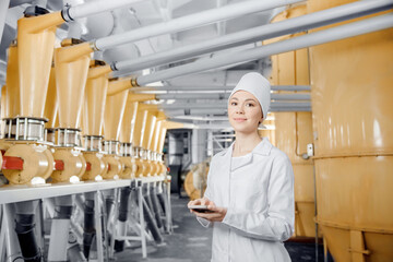 food industry Factory worker inspecting production line tanker in of flour mill with computer tablet © Parilov