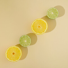 fresh summer fruit with lemon and lime on sandy background.flat lay minimal yellow green idea
