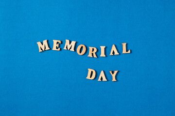 Fototapeta na wymiar Memorial Day text made from wooden letters on blue background