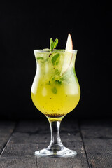 Glass of green apple mojito cocktail on the wooden background