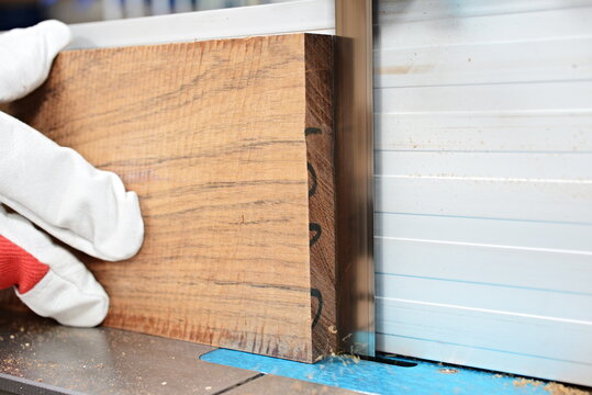Cutting of ovangkol wooden plate on band saw. Guitar making