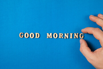 Good morning text made from wooden letters on blue background.