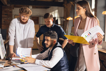 Colleagues working together in modern office using devices and gadgets during creative meeting