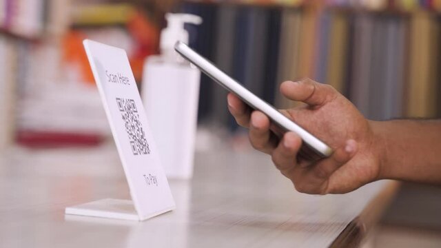 Close up of customer hands Scanning QR code for digital contact less payment after shopping at local shop - concept of technology, safety and healthcare during coronavirus covid-19 pandemics