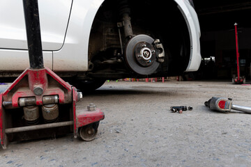 White cars change wheels using a lifting jack.