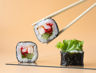 portion of Japanese rolls on a plate. sushi sticks hold a roll with shrimp, cucumber and caviar