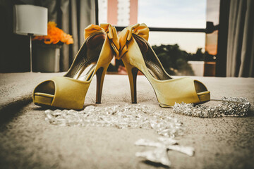 Sapatos de uma noiva com fundo para janela de um hotel de luxo.