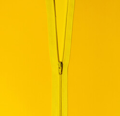 Half way open yellow zipper revealing another shade of yellow. Abstract top view, creative flat lay. © Ivan
