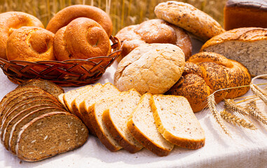 lot of different flavored bread, wheat, rye, on the table in the field outside