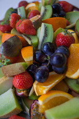 Fresh fruit salad, including sliced strawberries, blueberries, grapes, cantaloupe, and honeydew melon, for themes of health food, nutrition, freshness. High quality photo
