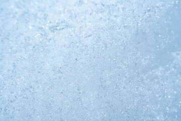 Background with close-up of snow under strong magnification. Slightly melted snow with sharp edges in soft focus.