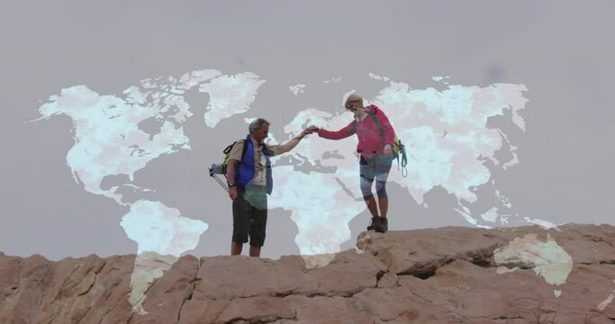 Caucasian senior couple hiking holding hands on cliff, over moving world map