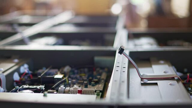 Slider shot video of electronic digital PCB boards on workshop table. Metal components and microcircuits lie on metal compartments during the production of cases of future powerful supercomputers