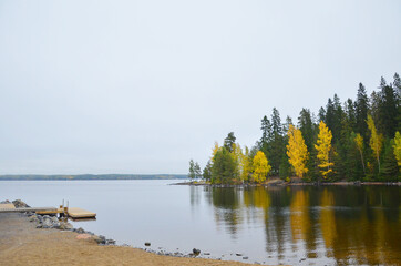 Beautiful reflection of boas and autumn forest on the lake, close to sauna of Rauhaniemi, Tampere,...