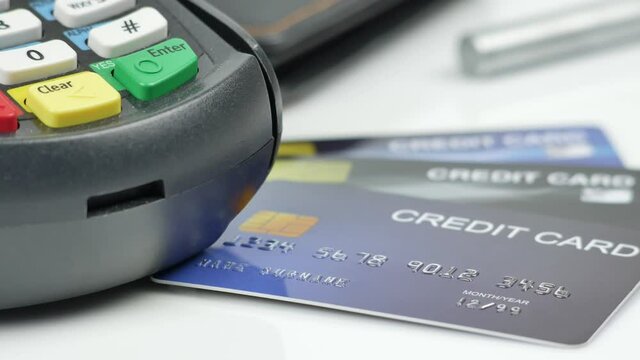 Credit card reader machine or Payment terminal with credit card on table slow pan 4K video