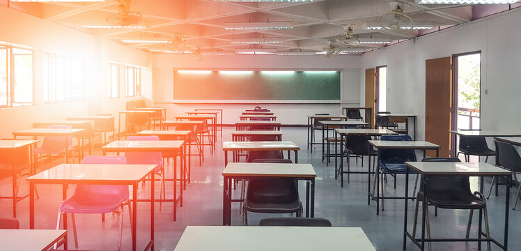 School Classroom In Blur Background Without Young Student; Blurry View Of Elementary Class Room No Kid Or Teacher With Chairs And Tables In Campus.