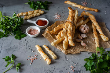 Grissini with cheese and garlic for breakfast on a gray background. Vegetarian dish