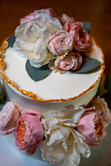 white cake decorated with live flowers. Traditional wedding cake. 