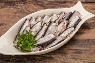 Anchovies in the bowl served basil leaves
