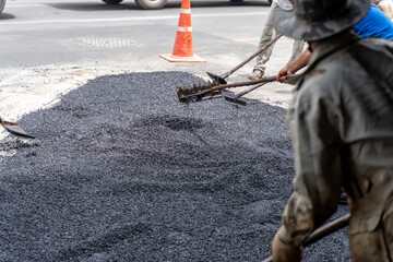 Workers making asphalt with shovels at road construction. (Motion)