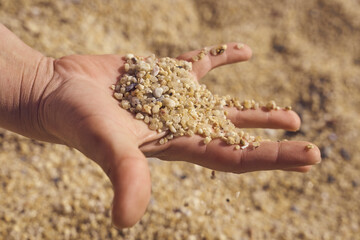 hand playing with the white sand of the beach