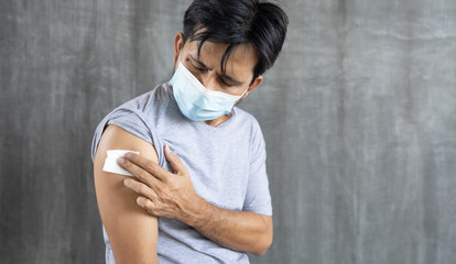 young asian man after getting vaccine covid-19