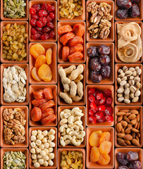 Seamless flat lay food background of dehydrated fruits, seeds and nuts on black. Non-perishable antioxidant gluten free foods concept