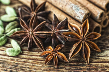 Anise stars, cinnamon, cardamom and on a wooden table. 