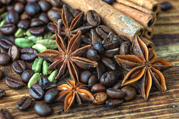 Anise stars, cinnamon, cardamom and roasted coffee beans on a wooden table. 