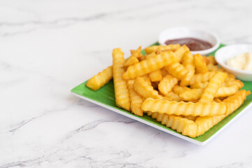 French fried potatoes on marble table background, Tasty french fries on marble background. Selective focus with copy space.