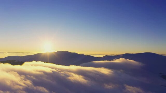 A beautiful and gentle view of an extraordinary and fluffy cloud valley and a bright orange sunset, aerial UHD 4K video