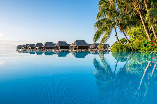 Infinity pool and overwater bungalows at a luxury beach resort
