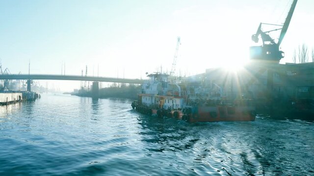 Old rusty fishing ship sailing on the river at dawn. Seed of a professional fishing vessel close-up at sunrise.