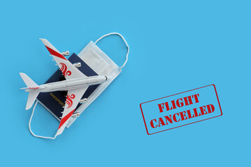 Plane model and face mask on a red background with text flight cancelled.