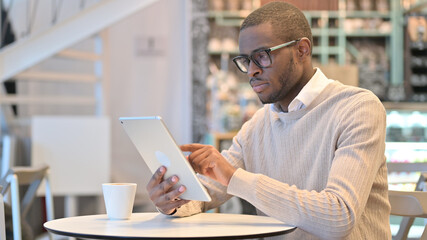 Serious Professional African Man using Tablet in Cafe 