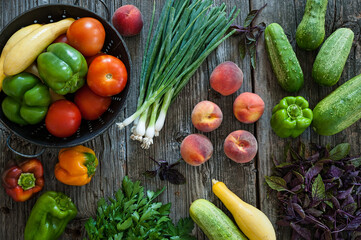 Overhead view of a variety of summer fruits, vegetables, and herbs.