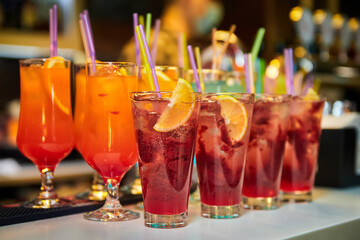 Multicolored alcoholic and non-alcoholic cocktails with ice and straws