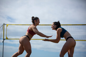 young women playing beach volleyball on a sunny day